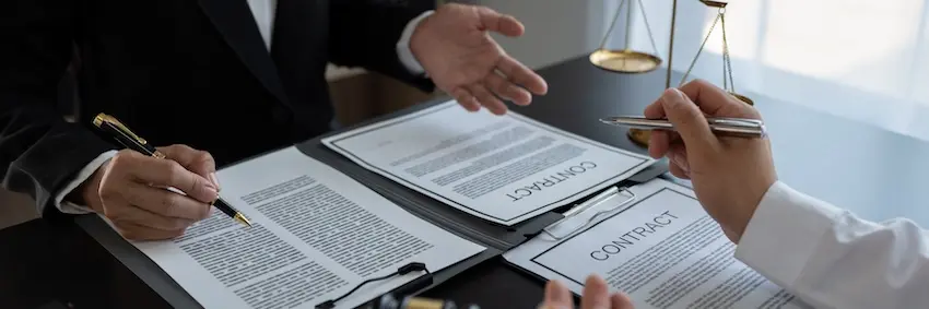 Car accident lawyer discussing insurance settlement with injured client in Atlanta office.