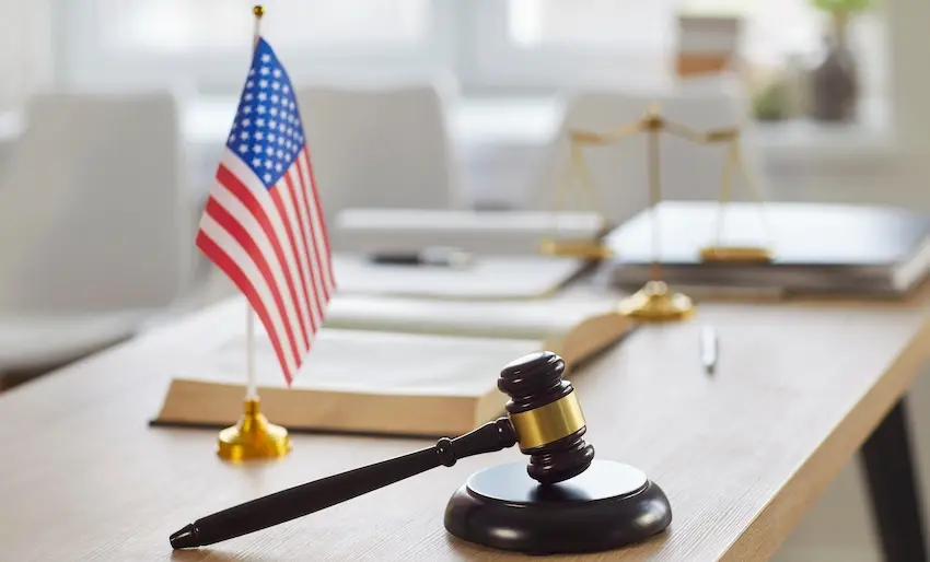 A judge's gavel and American flag are on a legal desk which are representing a neck injury accident litigation and personal injury compensation claims at Atlanta Metro Law.