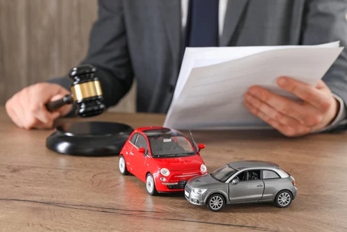 An Atlanta car accident lawyer holds a judge's gavel near model cars.